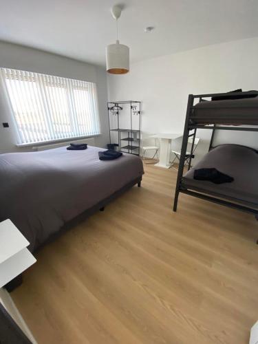 a bedroom with two bunk beds and a wooden floor at Vakantiehuis Joanitas in Bredene