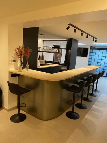 a kitchen with a bar with stools around it at Vakantiehuis Joanitas in Bredene