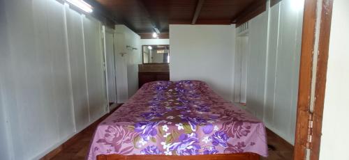 a bed in a room with a purple comforter at Koodaram Villa in Vagamon
