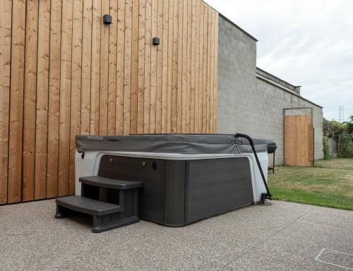 a hot tub sitting next to a wooden fence at Vakantiehuis Joanitas in Bredene
