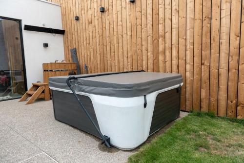 a bath tub sitting on the grass next to a fence at Vakantiehuis Joanitas in Bredene