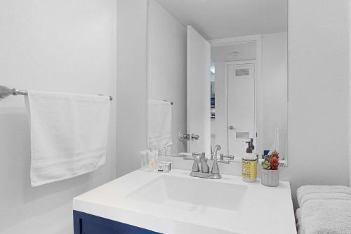 a white bathroom with a sink and a mirror at South River Condo in Austin