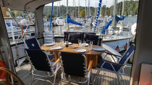 uma mesa e cadeiras num barco com barcos em Vedette Hollandaise de 13 m pour séjour insolite em Nivillac