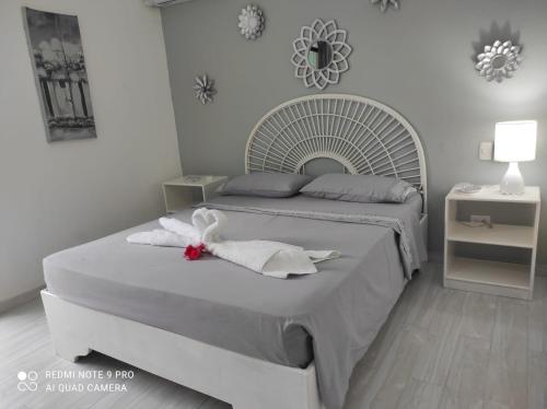 a white bedroom with two beds with towels on them at Villa Preciosa in Bayahibe