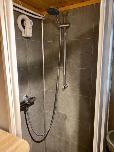 a shower with a shower head in a bathroom at Three bedroom holiday house with jacuzzi in Bjorli , pets allowed in Bjorli