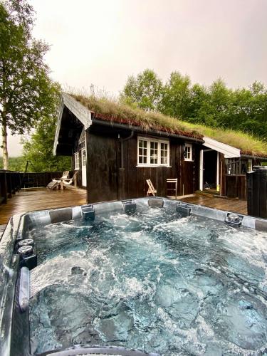 a hot tub in front of a house at Three bedroom holiday house with jacuzzi in Bjorli , pets allowed in Bjorli