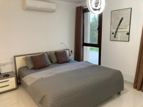a bedroom with a bed and a large window at Hawana Salalah Marina in Salalah