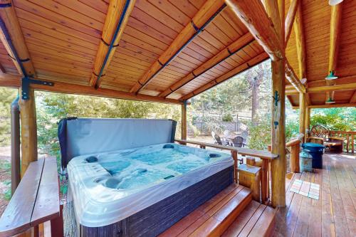 bañera de hidromasaje en una terraza con techo de madera en Branchwater Lodge, en Big Bear Lake