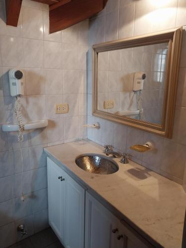 y baño con lavabo y espejo. en Why Not Guemes en Córdoba