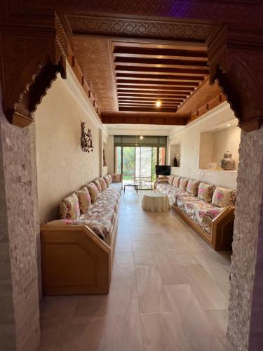 a large living room with couches and a table at Palmeraie 3 Vue Piscine et Jardin in Marrakech