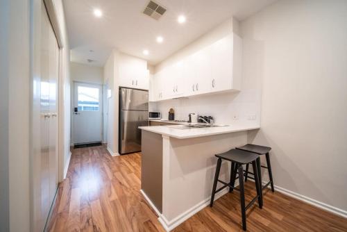 a kitchen with white cabinets and a bar with a stool at Black Oak at Brompton in Bowden