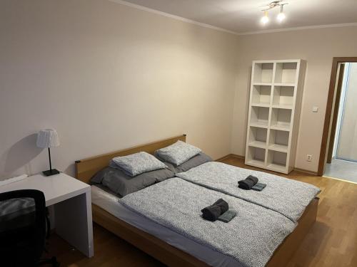 a bedroom with a bed with two slippers on it at Apartment 'ACTIVE LIFE' - near to Hockey, Football and Basketball stadium, VIVO Shopping center in Bratislava