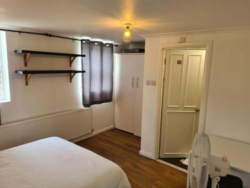 a room with a bed and a window and a door at Close To Tower Bridge Central London - 4 Bedroom House - 3 Bathrooms - Free Parking 3 Cars - Sleep 9 in London