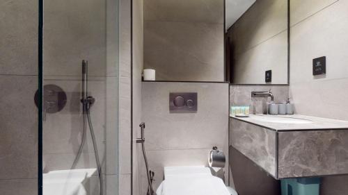 e bagno con doccia, servizi igienici e lavandino. di O Ten, Al Jadaf - Locations a Dubai