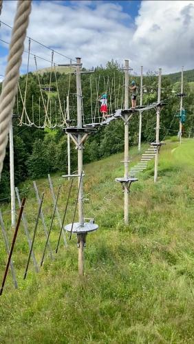 a row of swings in a field with people on them at Three bedroom holiday house with jacuzzi in Bjorli , pets allowed in Bjorli