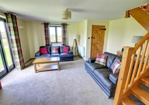 a living room with a couch and a table at Y Beudy in Llandinam