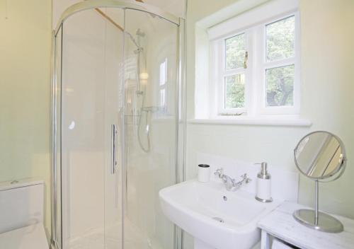 a white bathroom with a sink and a shower at Sampson's Mill in Wickham Market