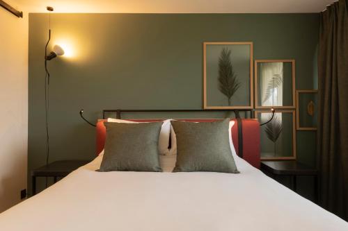 1 dormitorio con 1 cama blanca y 2 almohadas en Campanile Metz - Jouy-Aux-Arches, en Jouy-aux-Arches