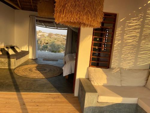 ein Wohnzimmer mit einem Sofa und einem großen Fenster in der Unterkunft LA DUNE DES SONGES in Anakao