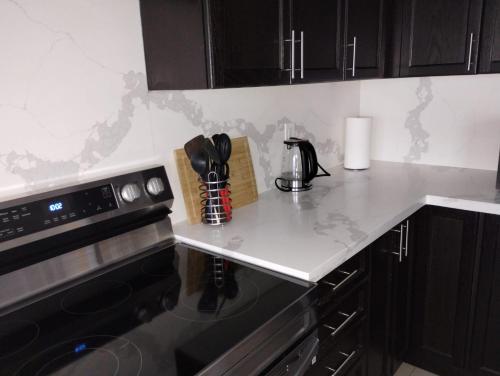 a kitchen with black cabinets and a counter top at luxurious 3-bedroom residential home in Lincoln in Beamsville