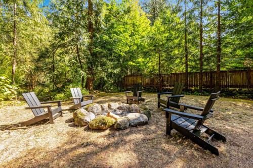 a group of three chairs sitting around a fire pit at John Lake Lodge in Rhododendron