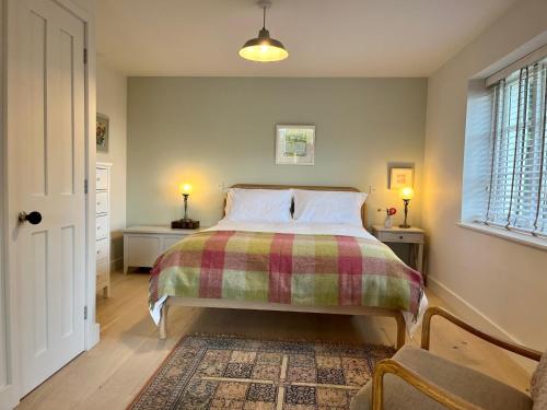 Cobblers Lodge في ليم ريجيس: غرفة نوم مع سرير وبطانية منقوشة
