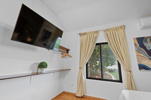 a living room with a tv and a window at H4 LAS CABAÑAS in Corozal