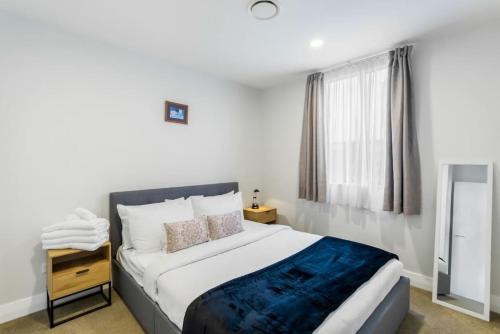 a bedroom with a large bed and a window at Quality in Heart of Albany - Wi-Fi - Free Parking in Auckland