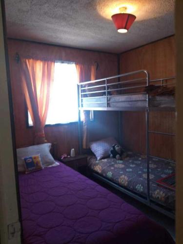 a bedroom with two bunk beds and a window at Casa 2 Habitaciones in Villarrica