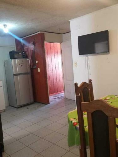 a room with a kitchen with a refrigerator and a table at Casa 2 Habitaciones in Villarrica
