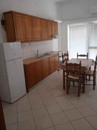 een keuken met een tafel en een witte koelkast bij Maria's house in Preveza
