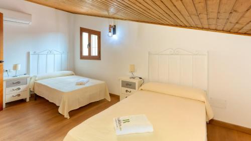 a bedroom with two beds and a window at La Pasadilla Alozaina by Ruralidays in Alozaina