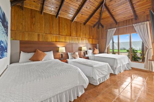 a bedroom with two beds with white sheets at H4 LAS CABAÑAS in Corozal