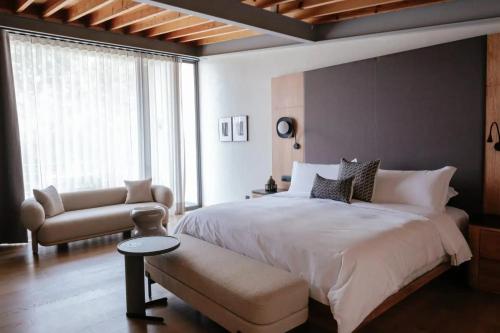 1 dormitorio con 1 cama blanca grande y 1 silla en Colima 71 Art - Community - Hotel, en Ciudad de México