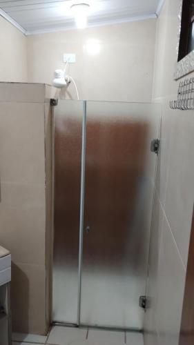 a shower with a glass door in a bathroom at Sitio Arco Iris da Lia in São Roque