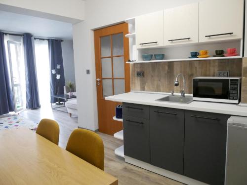 a kitchen with a sink and a table with chairs at Altavista mountain apartment in Samokov