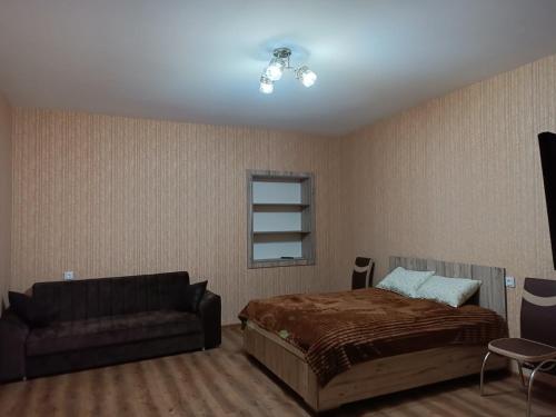 um quarto com uma cama e um sofá em квартира в сололаке em Tbilisi