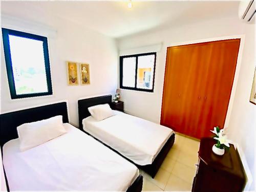 a bedroom with two beds and a wooden door at Mackenzie apartment 301 in Larnaca