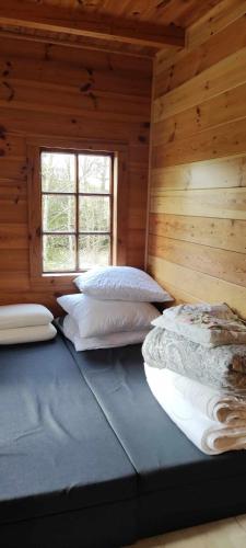 Duas camas num chalé de madeira com uma janela em Dom na Kresach Grzybowszczyzna 
