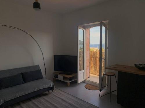 a living room with a couch and a large window at T3 vue mer in Le Lavandou