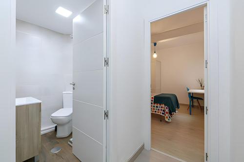 ein weißes Bad mit einem WC und einem Waschbecken in der Unterkunft Piso Ría de Pontevedra in Pontevedra