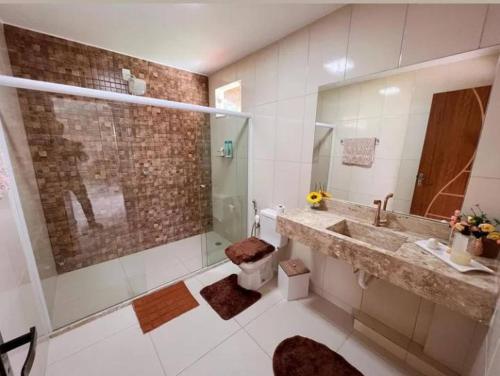 W łazience znajduje się umywalka, toaleta i lustro. w obiekcie Casa de Praia Pontal w mieście Ilhéus