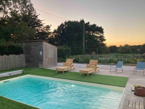 einen Hinterhof mit einem Pool mit Stühlen und einer Terrasse in der Unterkunft La villa Mama (65 m2), avec piscine partagée in Erquy