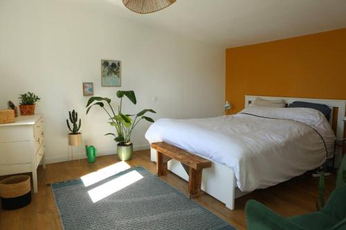 1 dormitorio con cama, mesa y alfombra en La villa Mama (65 m2), avec piscine partagée, en Erquy
