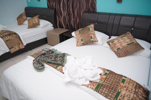 two beds in a room withskirts at Langkawi Country Lodge2 in Pantai Cenang
