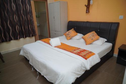 a bedroom with a large bed with orange pillows at Langkawi Country Lodge2 in Pantai Cenang