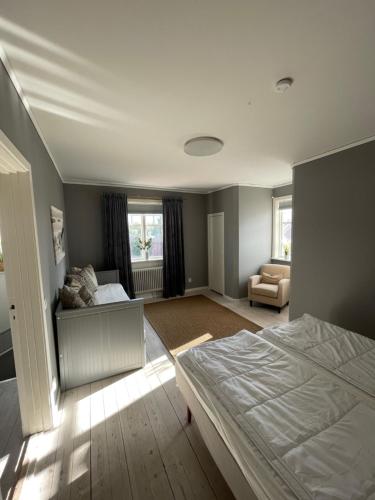 um quarto com uma cama e um sofá em Fin lägenhet i centrala Leksand em Leksand
