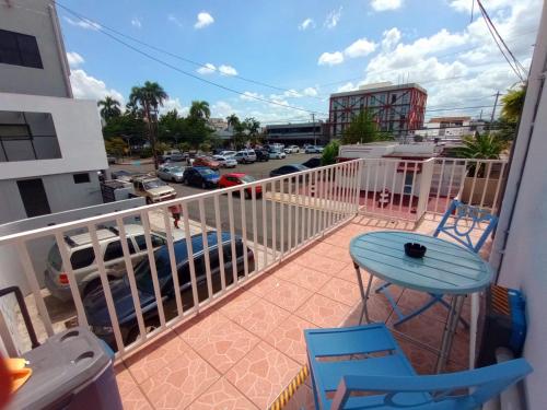 einen Balkon mit einem Tisch und Stühlen sowie einen Parkplatz in der Unterkunft Urban Lodgings One @ Roosevelt 457 in San Juan