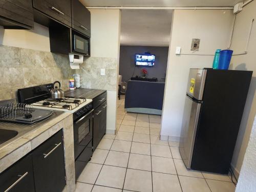uma cozinha com um fogão e um frigorífico em Departamento 2 Recamaras 1 Baño Cocina y sala em Matamoros