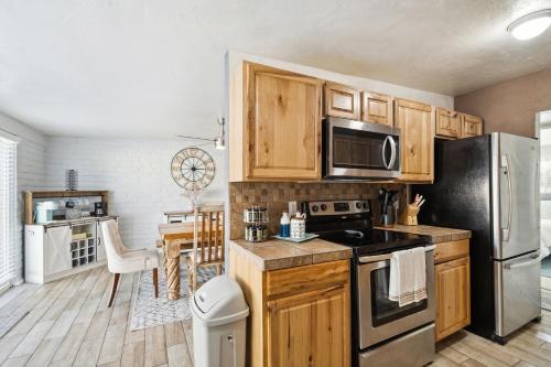 a kitchen with wooden cabinets and a stainless steel refrigerator at Four-Bedroom Holiday Home in Tucson